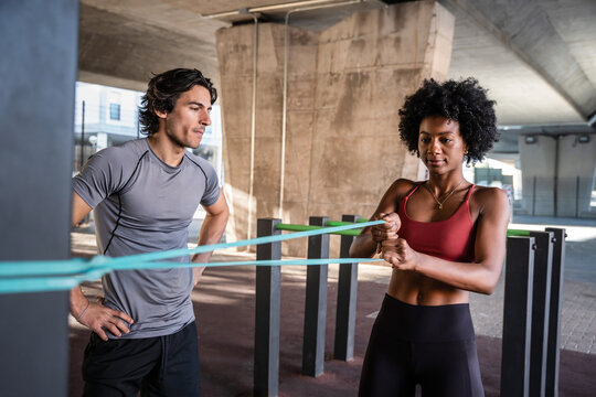 Outdoor resistance band workout with trainer coaching athlete