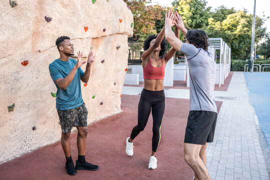 Friends celebrate workout success with high five outdoors