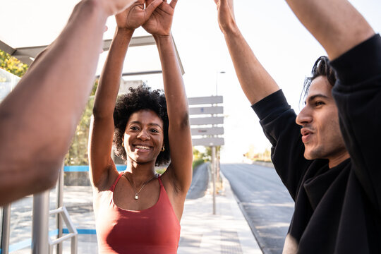 Friends celebrating with raised hands at an outdoor stop