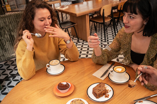 Friends enjoying coffee and dessert at a cozy cafe table