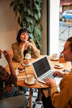 Multiethnic friends discuss work over coffee in a cafe