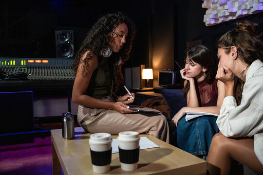 Music producer coaching singer during studio writing session