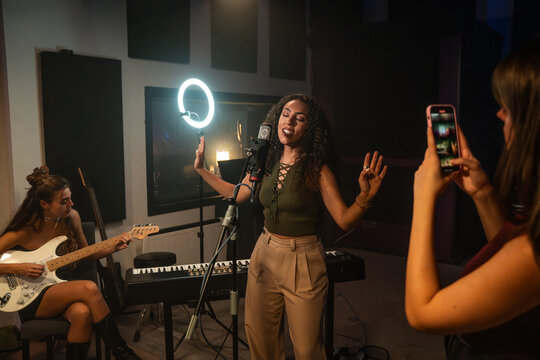 Singer records studio performance with ring light and phone