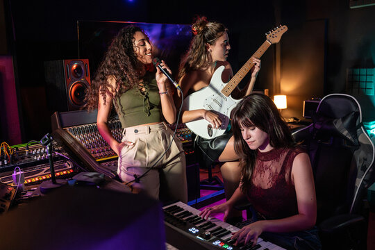 Female band recording song in music studio with keyboard