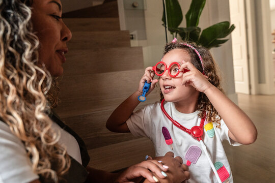 Child in toy doctor play with parent at home indoors