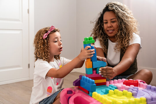 Child and mother building colorful blocks at home playtime