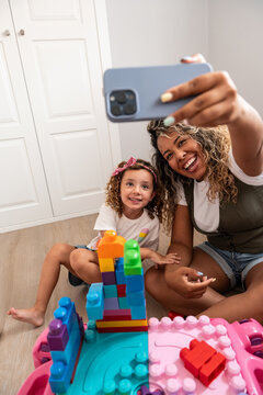 Mother and daughter taking a selfie while playing at home