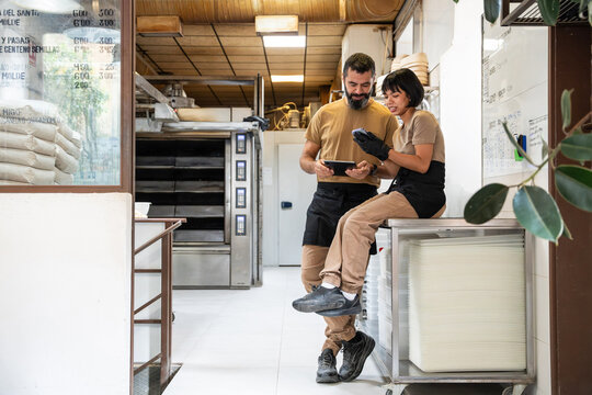 Bakery team checking inventory and orders in artisan bakery