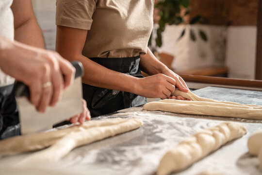 Artisan bakers shaping dough on a floured worktable
