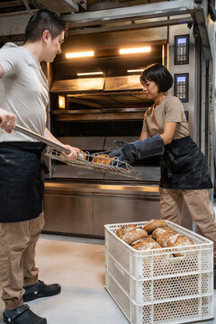 Baker team loading artisan bread from industrial oven
