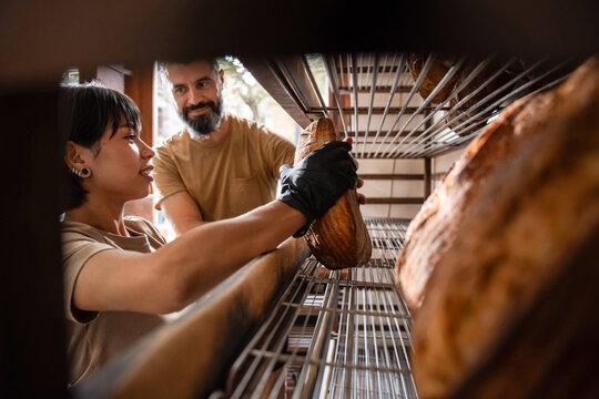 Artisan bakery staff placing sourdough loaf on rack