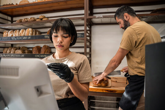 Artisan bakery staff at counter with bread in background