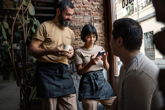 Bakery staff using mobile order in artisan bakery cafe