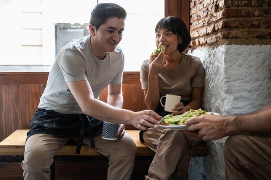Bakery staff sharing lunch break in rustic cafe corner
