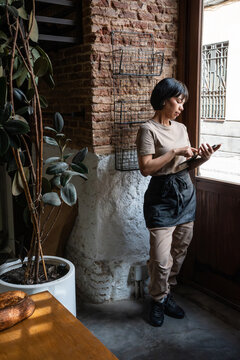 Bakery staff using tablet by window in artisan bakery