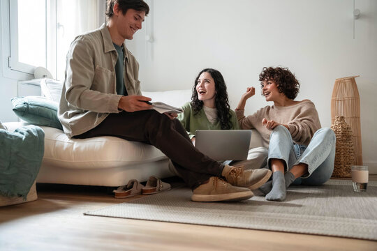 Young adult group chatting with laptop in cozy living room
