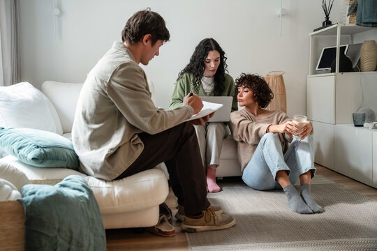 Friends planning project and budgeting at home in living room