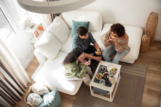 Friends share snacks in bright living room at home