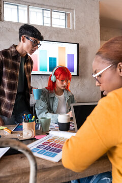 Diverse team meeting in office with charts and laptop