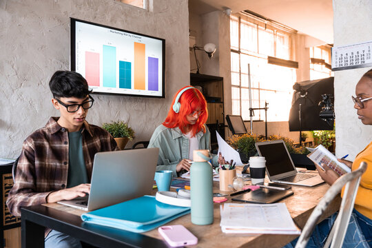 Team working at creative office with laptop and chart