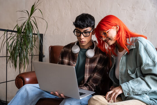 Young friends using laptop together in cozy home setting