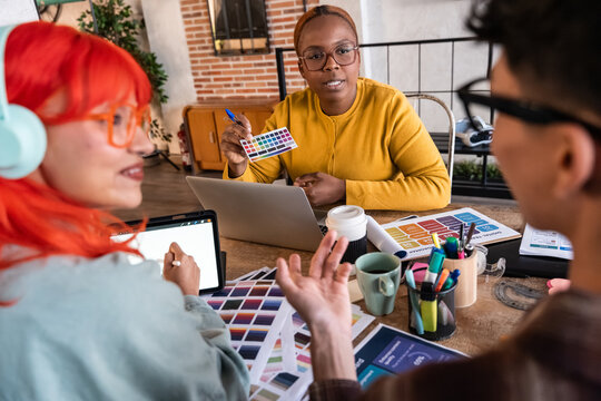 Creative team meeting with color palette and laptop