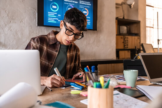 Young designer sketching ideas at creative studio desk