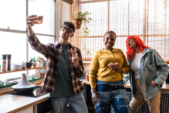 Friends taking selfie in cozy kitchen with natural light