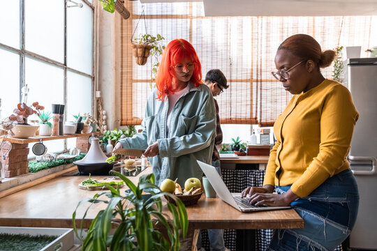 Diverse friends preparing healthy food and working in kitchen