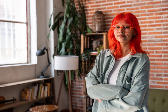 Portrait of confident red haired designer in modern loft studio