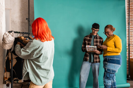 Fashion team selecting outfit and colors in photo studio set