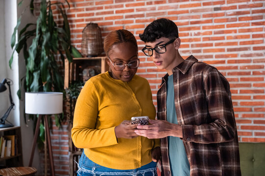 Two colleagues review a smartphone message in modern office