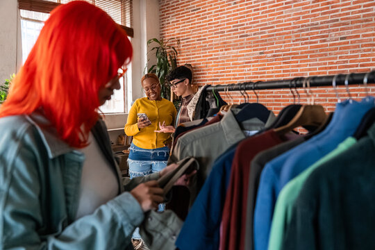 Multiethnic team selecting clothing for fashion production