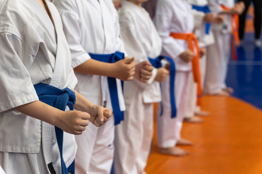 Children in white karate gi with blue and orange belts