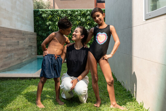 Hispanic family enjoying backyard pool time and summer fun