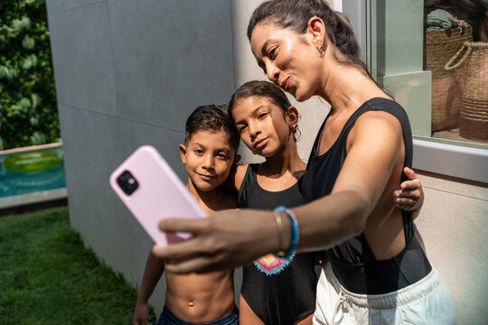 Hispanic family taking a selfie together outdoors at home