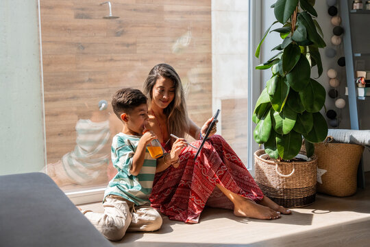 Hispanic mother and son using tablet at home together