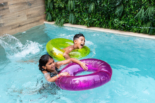 Hispanic family enjoying summer fun with pool float rings