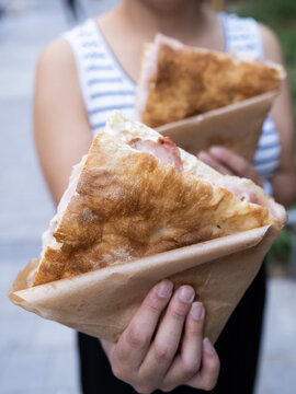UGC of fresh focaccia sandwich in paper wrap outdoors