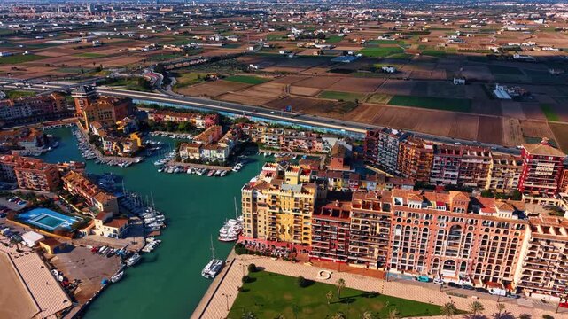 Aerial panorama of Port Saplaya marina and fields. Aerial panorama of Port Saplaya marina, colorful buildings, highway and farmland near Valencia, Spain.