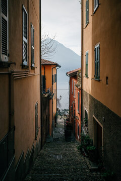 Narrow European alleyway leading to a serene lake view