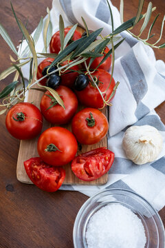 Rustic still life with tomato, olive, garlic and salt