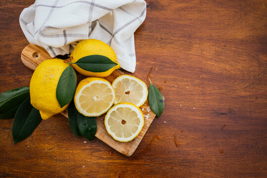 Fresh lemon slices on cutting board on rustic wood table