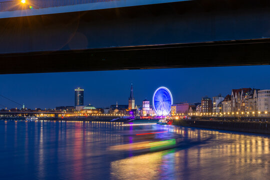 Dusseldorf riverside nightlife with ferris wheel at dusk