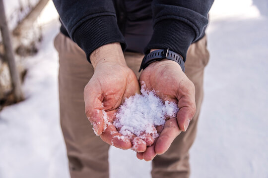 Hands holding fresh snow outdoors in winter close-up