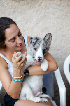 Young woman cuddling a border collie puppy outdoors