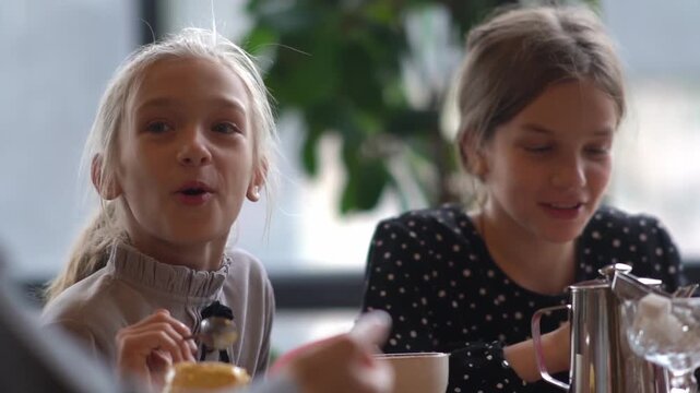 Children in a cafe. A family in a cafe, children close-up drinking cocoa, laughing and chatting. High quality FullHD footage