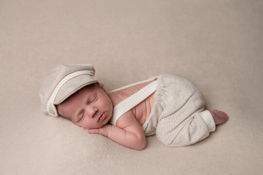 Sleeping newborn baby in soft beige outfit and cap