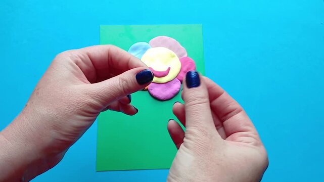 Creating funny flower face from plasticine, adding eyes and smile, creative kids craft