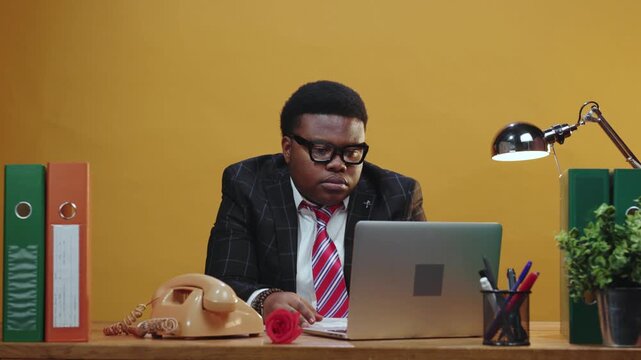 A professional in a suit working diligently at their desk with a phone and office supplies